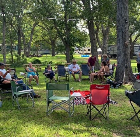 people sitting on grassy area in picnic chairs